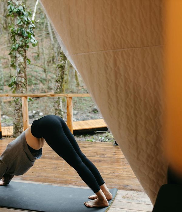 A person demonstrating a flexible yoga stretch on a mat.
