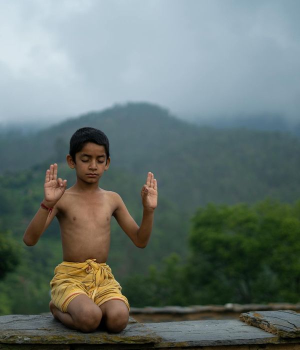 A serene woman sitting in a lotus yoga pose in a calm environment.