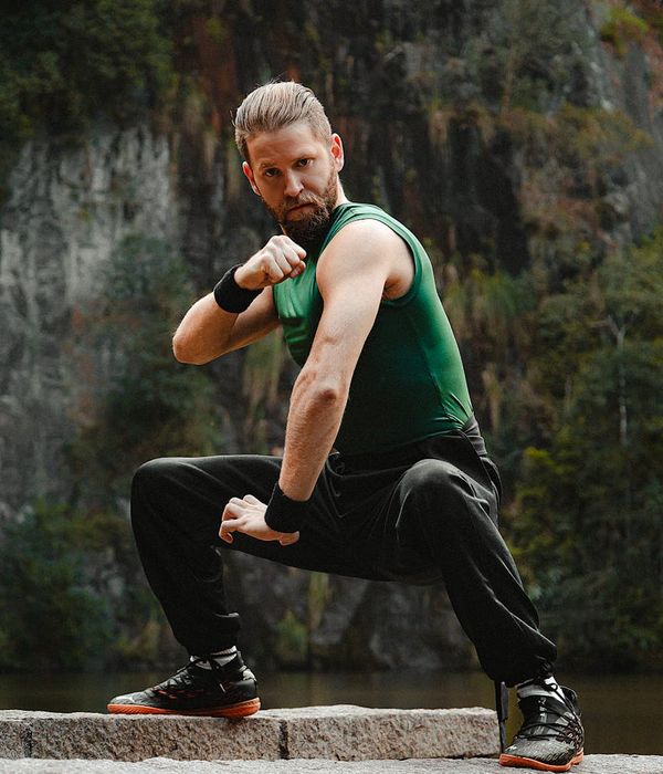Man in a strong warrior yoga pose showing balance and power.